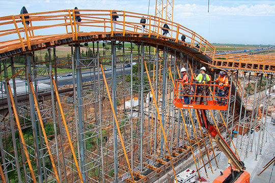 Bridge under construction with a crane beside it