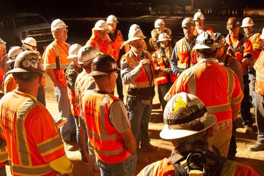Group of construction workers meeting at night