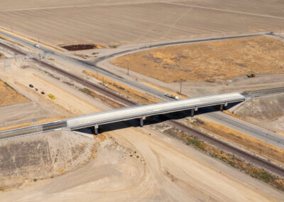 Taken from above via drone, the Avenue 88 Grade Separation predominates the photo, taking center stage. Parched earth surrounds it on all sides, as it passes over State Route 43 and the BNSF freight railroad tracks below, as well as the eventual location of high-speed rail tracks.